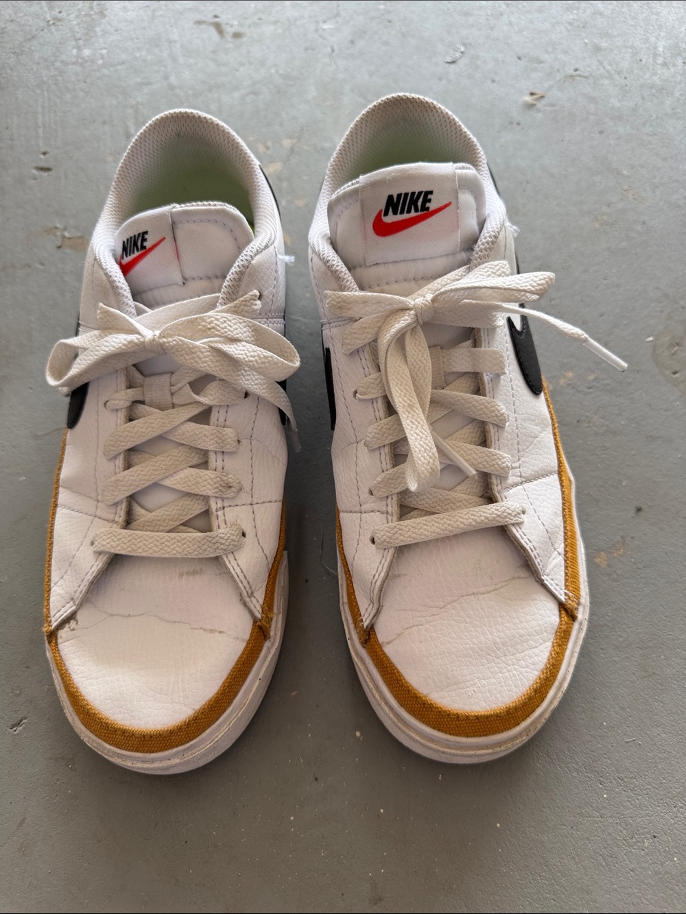 Nike White Low-Top Sneakers with Black Swoosh and Mustard Accents